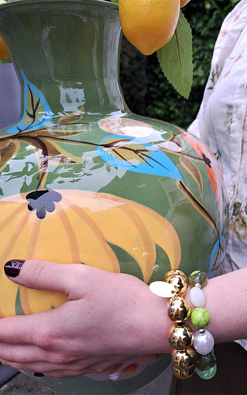260429-Home-2 Handgemaakte sieraden Horst – vrouw draagt roze kralenketting en zilveren kettingen met smileys, sterretjes en klavertje vier van Steyl Sieraden